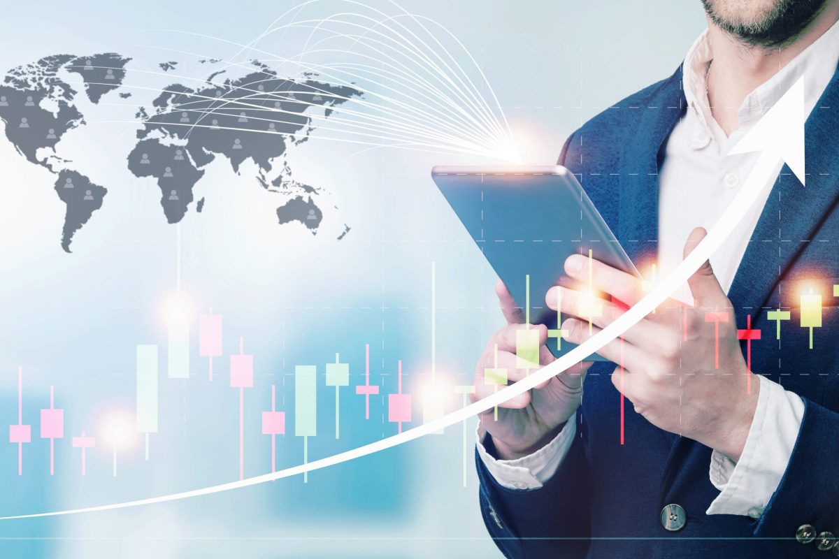 Double exposure of businessman using the tablet with cityscape and financial graph on blurred building background, Business Trading concept.